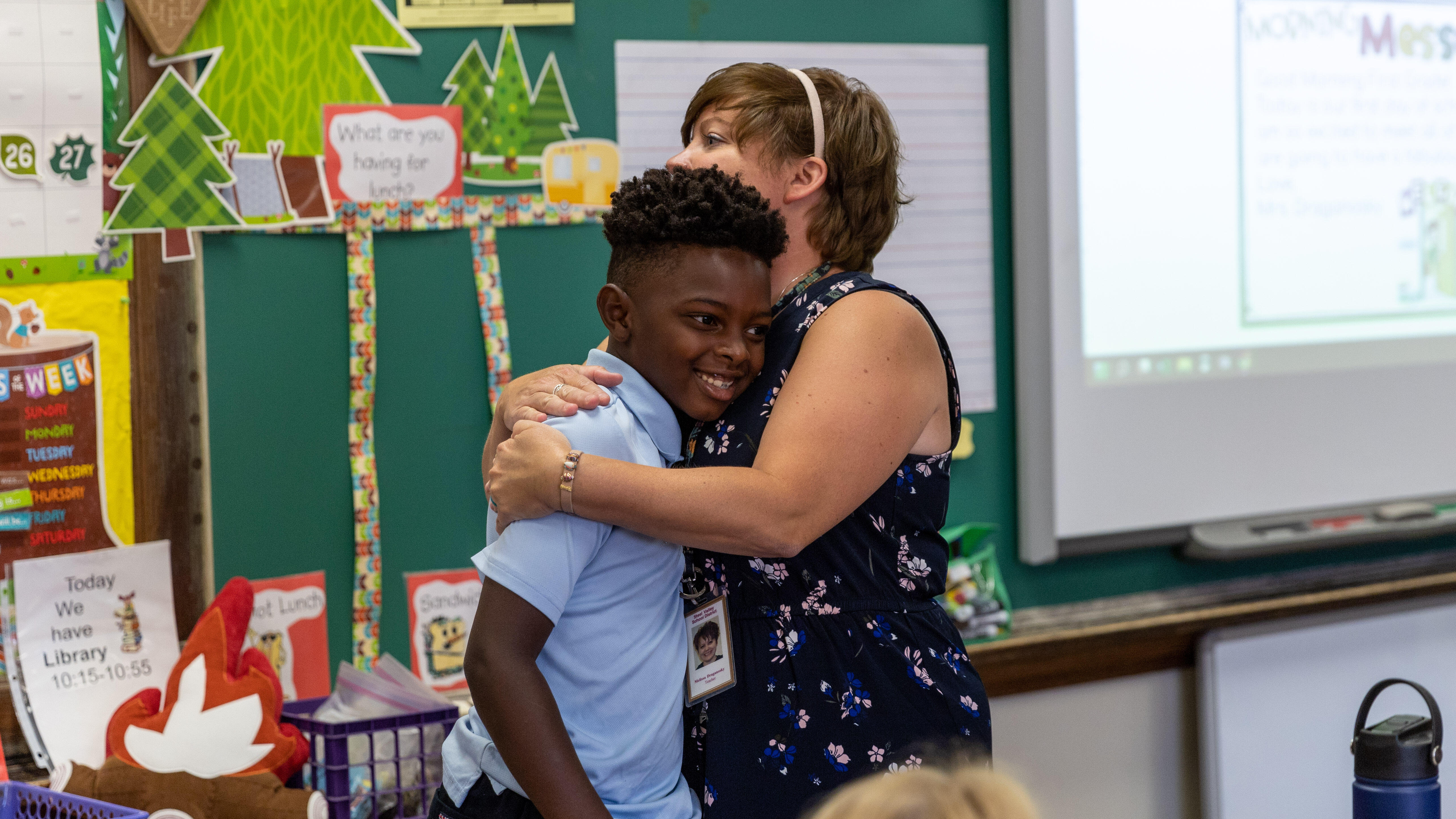 A student hugs a teacher